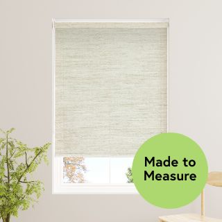 An image of a window with a cream textured roller blind partly covering the window.