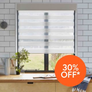 An image of a window in a kitchen with a Zebra Day & Night blind partially covering the window 